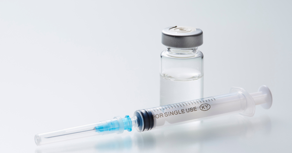 Clear medical vial and syringe on a white surface representing Ozempic weight loss treatment medication.