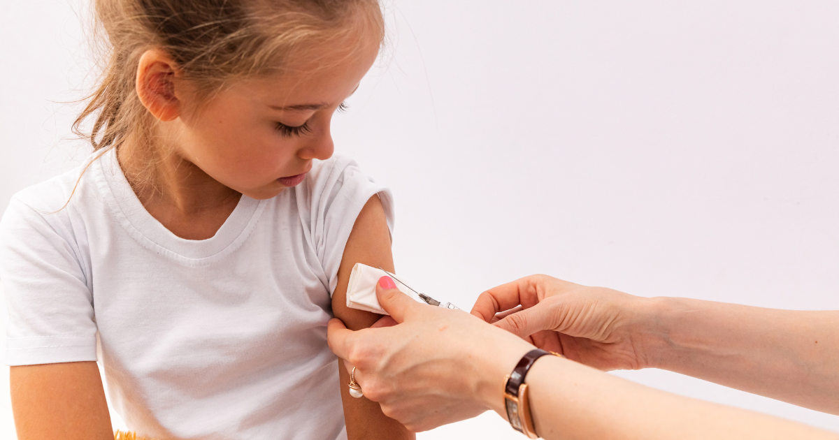 Child receiving an upper-arm injection from a healthcare professional, illustrating gentle technique and calm patient experience