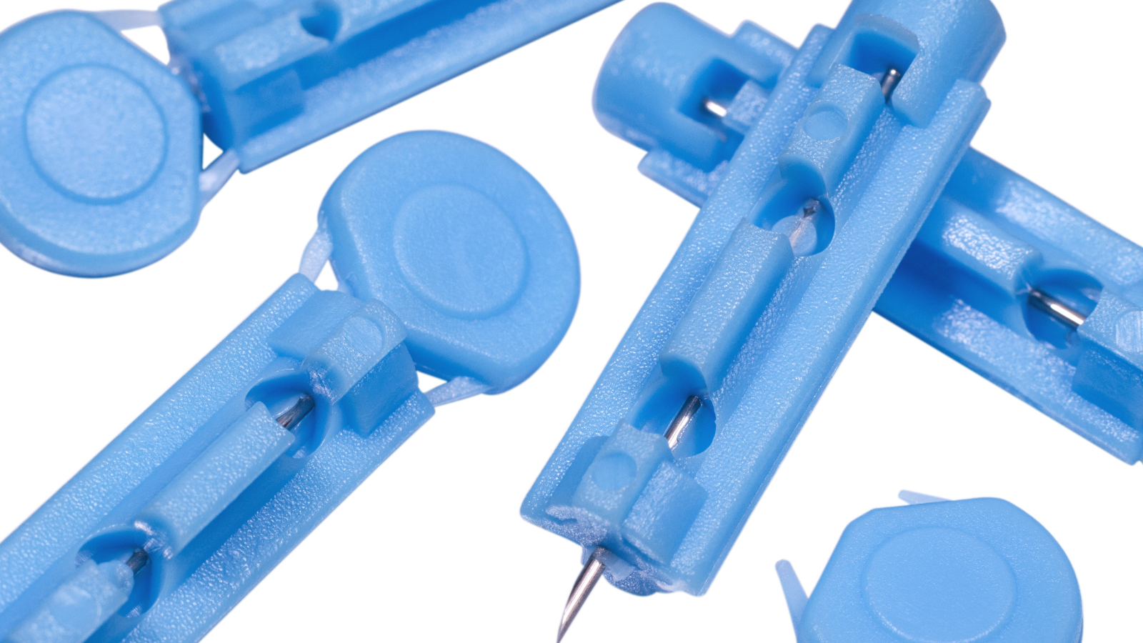 Close-up of blue sterile lancets used for blood sugar testing in diabetes care