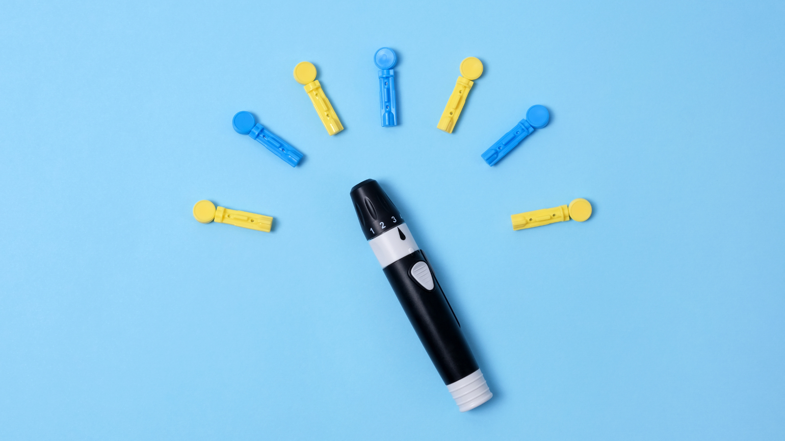 Lancing device with blue and yellow sterile lancets for diabetes arranged in a semicircle on a light blue background