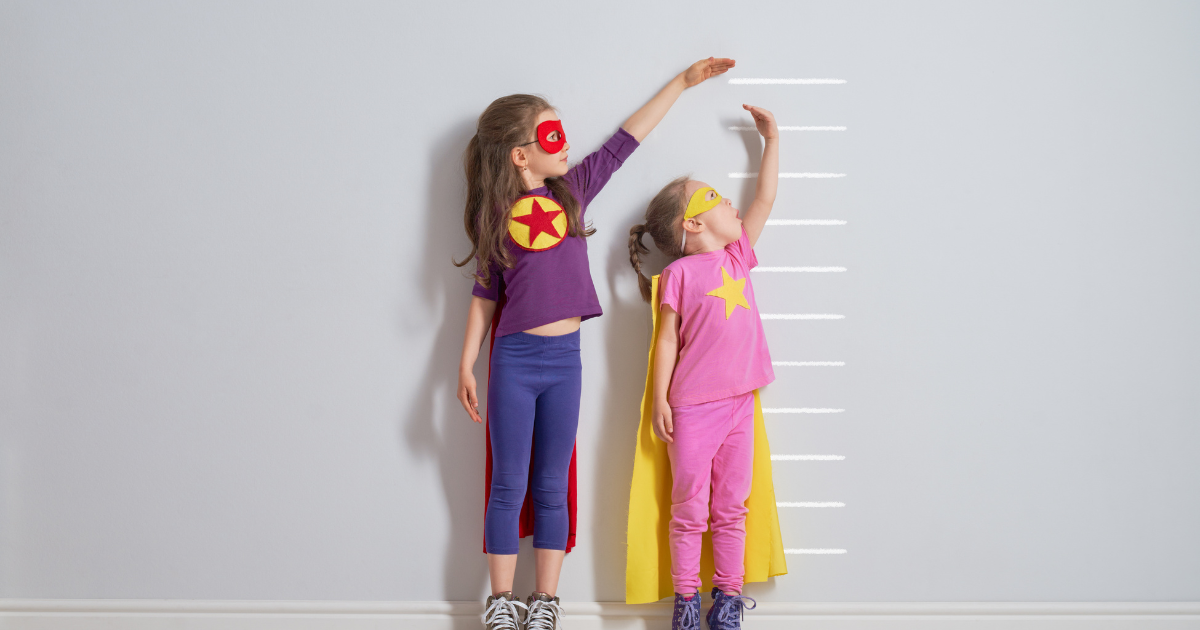 Two toy dolls standing against a wall, symbolizing child growth and development in a simple, playful representation.