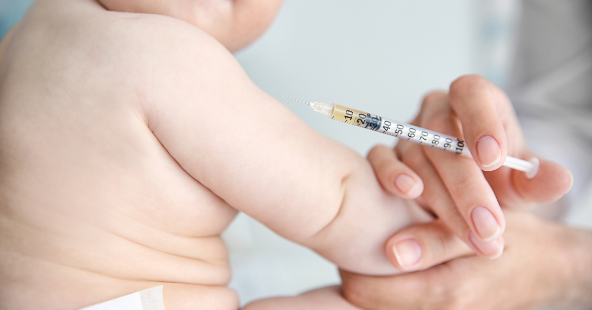 Close-up of a nurse gently administering a vaccine for newborns in a clinical setting